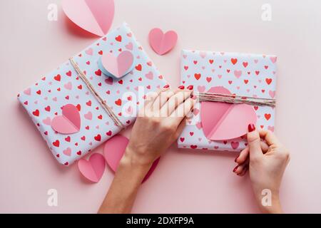 Elegante weibliche Hände schmücken mit Herz Geschenkboxen für valentinstag. Stockfoto