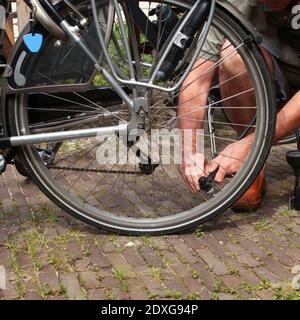 Mann mit Ventil zum Aufblasen von Luft im Reifen des Fahrrads Stockfoto