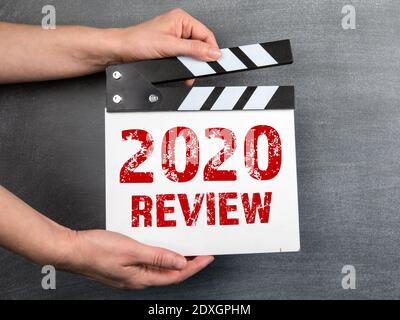2020 Überprüfung. Geschäftskonzept. Film Klapper in Frau Hand. Schwarzer Kreidetafel Hintergrund. Stockfoto