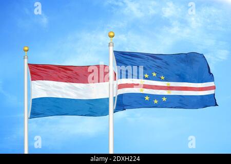 Niederlande und Kap Cabo Verde zwei Flaggen auf Fahnenmasten und Blauer Himmel Stockfoto