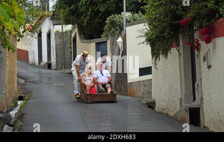 Funchal Madeira älteres Paar mit bergab Korbfahrt. Stockfoto