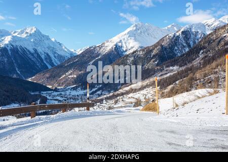 Winterlandschaft des Engadiner Tals an einem sonnigen Morgen, Guarda, Unterengadin, Graubünden, Schweiz. Blick von der Straße hinunter in die Stockfoto