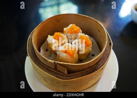 Schweinefleisch und Garnelen Dim Sum (Chinesische Knödel in gedämpftem Holzkorbbehälter serviert) Stockfoto