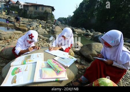 Eine Reihe von Kindern studierte entlang des Ciliwung River, Bogor City, während der Covid-19 Pandemie Stockfoto