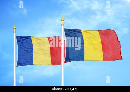 Rumänien und Tschad zwei Flaggen auf Fahnenmasten und blauer Himmel Stockfoto