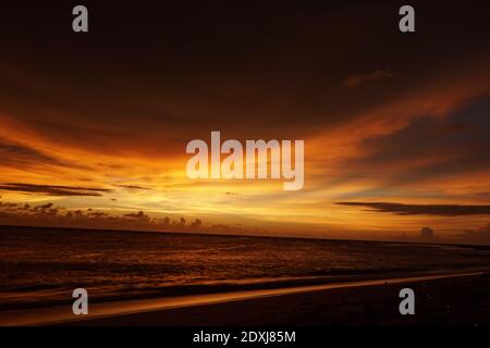 Eine faszinierende Aufnahme eines mysteriösen Sonnenuntergangs mit dem rot-gelben Himmel in Cabo Ledo, Luanda - Angola Stockfoto