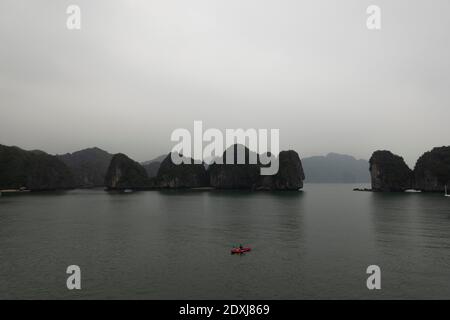 Kajakfahrer paddeln zwischen den Inseln der Ha Long Bay Stockfoto