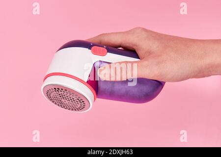 Ein wooman hält Stoff Rasierer auf dem rosa Hintergrund. Nahaufnahme, selektiver Fokus Stockfoto