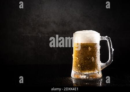 Gefrorener Bierkrug auf dunklem Hintergrund, mit Kopierplatz. Stockfoto