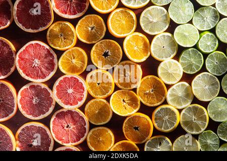 Bunte Früchte im Hintergrund. Zitrusscheiben, Orange, Zitrone, Limette und Grapefruit. Draufsicht Stockfoto