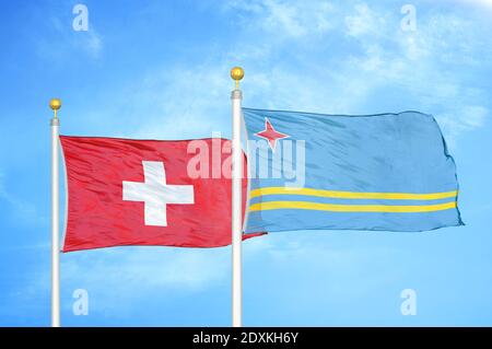 Schweiz und Aruba zwei Flaggen auf Fahnenmasten und blauer Himmel Stockfoto