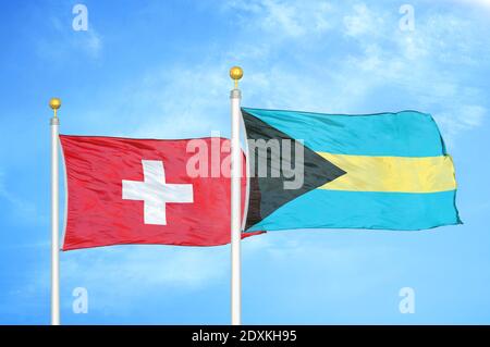 Schweiz und Bahamas zwei Flaggen auf Fahnenmasten und blauer Himmel Stockfoto