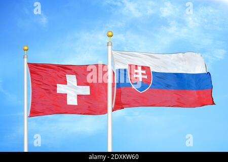 Schweiz und Slowakei zwei Flaggen auf Fahnenmasten und blauer Himmel Stockfoto