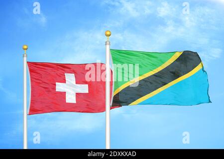 Schweiz und Tansania zwei Flaggen auf Fahnenmasten und blauer Himmel Stockfoto