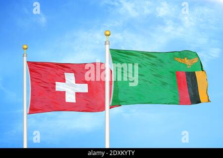 Schweiz und Sambia zwei Flaggen auf Fahnenmasten und blauer Himmel Stockfoto