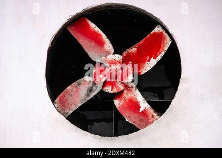 Großer alter roter Ventilator in der Betonwand. Stockfoto
