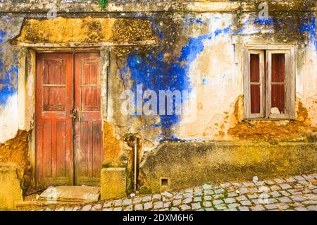 Alte Wände und Tür einer ruinierten blau bemalten Hütte Im Dorf Aljezur Algarve Bezirk Portugal EU Europa Stockfoto