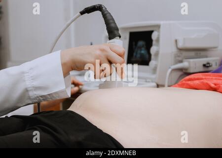 Nahaufnahme einer schwangeren Frau, die im Krankenhaus Ultraschalluntersuchungen durchgeführt hat Stockfoto
