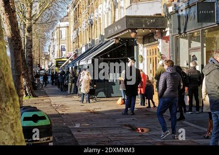 London, Großbritannien. Dezember 2020. The Traditional Xmas Queue Outside Metzger Macken Brothers, Chiswick, Xmas Eve 2020. Kredit: Peter Hogan/Alamy Live Nachrichten Stockfoto