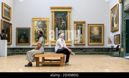 London, Großbritannien, 24. Juli 2020. Zwei Assistenten sitzen im Raum der Präraffaeliten, Tate Britain. Stockfoto