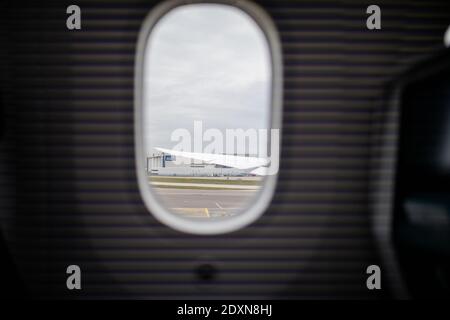 Flughafen und wolkigen Himmel aus einem Flugzeugfenster Stockfoto