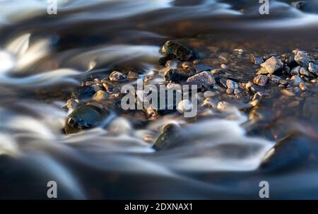 Lange Exposition von Fluss fließt vorbei an Felsen auf Cotterdale Beck, Yorkshire Dales National Park, Großbritannien. Stockfoto