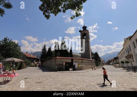 BULGARIEN, BANSKO - 02. AUGUST 2019: Kirche der Heiligen Dreifaltigkeit mit dem Pirin-Gebirge im Hintergrund Stockfoto