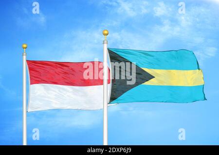 Indonesien und Bahamas zwei Flaggen auf Fahnenmasten und blau bewölkt Himmel Stockfoto