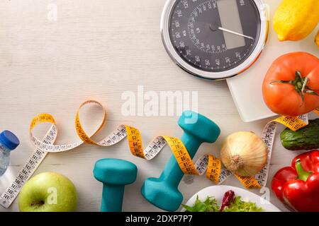 Gesunde Ernährung und Sport Hintergrund auf einem weißen Holz mit Skala und Maßband. Draufsicht. Horizontale Zusammensetzung. Stockfoto