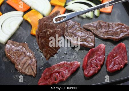 Gegrilltes Fleisch durch elektrische Grillplatte, ein seltener Teil des japanischen Wagyu Rindfleisch genannt Senbon Stockfoto