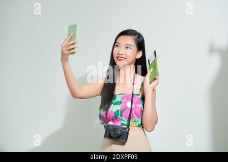 Asiatische junge Frau, die ein Selfie mit einem Pass und Flugticket vor dem Einsteigen Zeit für eine Sommerreise. Stockfoto