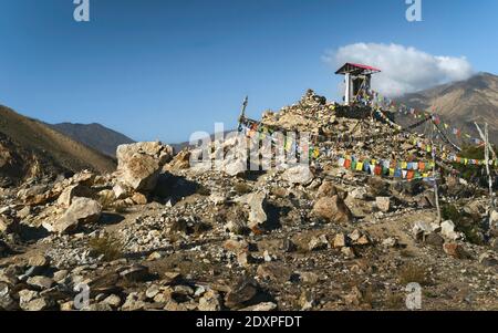 Buddhistisches Gebetsrad unter Gehäuse auf Berggipfel im Himalaya und strahlend blauer Himmel inmitten natürlicher Landschaft. Nako, Himachal Pradesh, Indien. Stockfoto