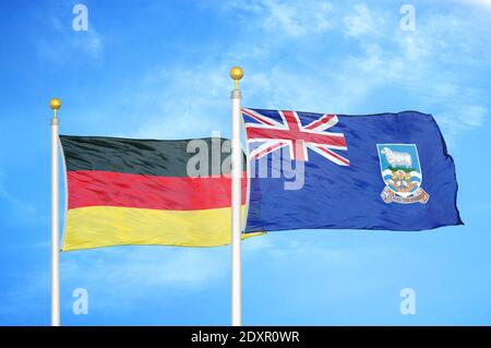 Deutschland und Falklandinseln zwei Flaggen auf Fahnenmasten und blau wolkiger Himmel Stockfoto