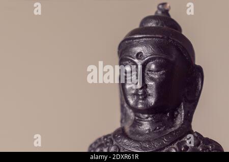 Nahaufnahme einer Buddha-Statue vor beigem Hintergrund. Speicherplatz kopieren. Stockfoto