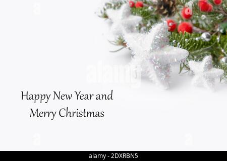 Weihnachtskarte mit einem grünen Zweig eines Weihnachtsbaums mit roten Beeren und einem Tannenzapfen auf weißem Hintergrund. Zusammensetzung der Weihnachtsferien. Stockfoto