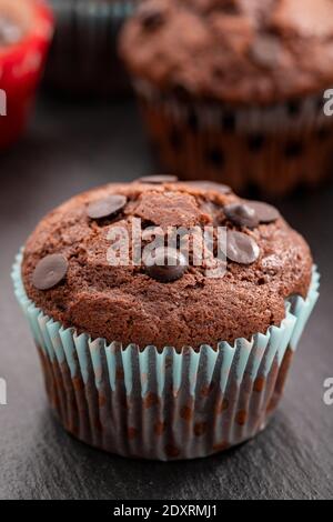 Schokoladenmuffin. Muffin oder Tasse Kuchen mit Schokolade bestreut. Vertikale Ansicht. Nahaufnahme. Stockfoto