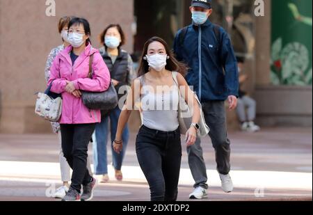 Hongkong, China. Dezember 2020. Fußgänger mit Gesichtsmasken gehen auf einer Straße in Hongkong, Südchina, 24. Dezember 2020. Das Zentrum für Gesundheitsschutz in Hongkong (CHP) meldete am Donnerstag 71 weitere bestätigte Fälle von COVID-19, insgesamt 8,424. Quelle: Wu Xiaochu/Xinhua/Alamy Live News Stockfoto