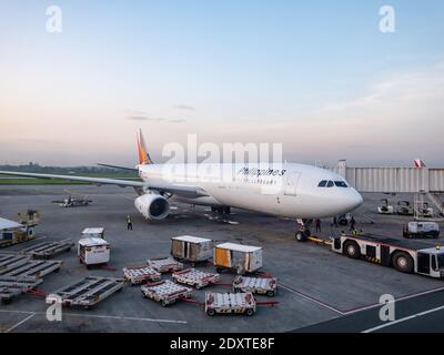 Philippine Airlines Airbus A330 wird am frühen Morgen im Terminal 2 des internationalen Flughafens Ninoy Aquino in Manila, Philip, zur Abfahrt vorbereitet Stockfoto