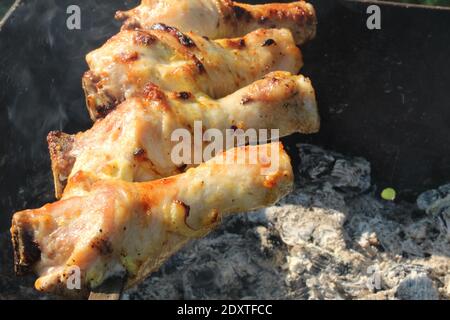 Hähnchenbeine sind gegrillte Spieße über Holzkohle Grill Picknick. Stockfoto