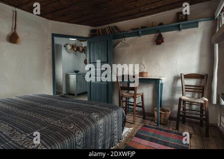 Traditionelle Innenausstattung des alten Schlafzimmer mit handgefertigten Holzmöbeln und Traditionelle Folk Ornament Textil in historischen Land Dorfhaus Stockfoto