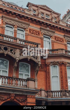 Niedriger Winkel Blick auf traditionellen roten Backstein-Apartmentblock mit Balkonen in Mayfair, London, Großbritannien. Stockfoto