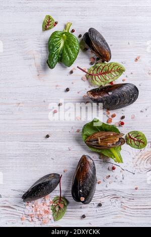 Heller Holzfood Hintergrund mit Gewürzen, frischen Muscheln, Zitrone. Draufsicht, Kopierbereich Stockfoto