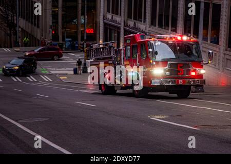 Seattle, WA – 22. März 2019; roter kommunaler Feuerwehrwagen fährt mit Lichtern und Sirenen bergauf, als er auf einen Notfall in der Innenstadt unter h reagiert Stockfoto