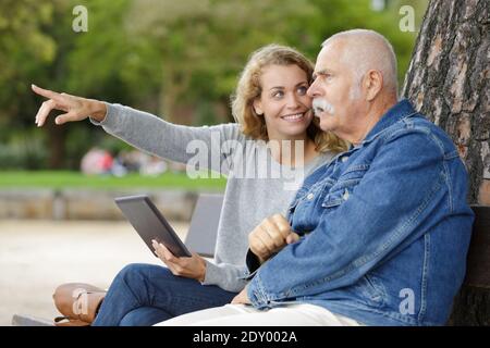 Tochter mit älteren Vater umarmt auf Parkbank Stockfoto