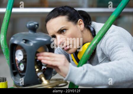 Frau, die den Gaszug auf der Lötlampe anpasst Stockfoto