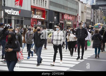 Menschen maskiert, aber Shopping am Black Friday, Auftakt der Weihnachts-Shopping-Saison 2020 während der Covid-19 Pandemie entlang 34th Street in Manhattan, New York City. Stockfoto