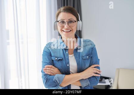 Portrait von zuversichtlich mittleren Alters reifen Frau trägt Brille und Kopfhörer Stockfoto