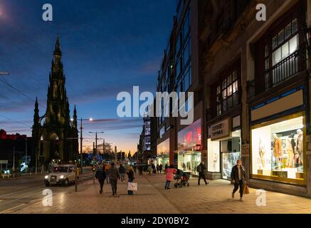 Edinburgh, Schottland, Großbritannien. 24 Dezember 2020. Schöner Heiligabend und Brexit Deal Sonnenuntergang über Edinburgh entlang einer ruhigen Princes Street mit ein paar Einkäufern, die Last-Minute-Weihnachtsgeschenk Einkäufe in den Verkauf angesehen. .Iain Masterton/Alamy Live News. Stockfoto