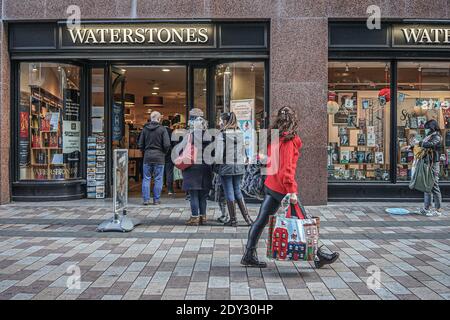 Belfast, Antrim, Großbritannien. Dezember 2020. Kunden mit Gesichtsmasken als Vorsichtsmaßnahme gegen die Ausbreitung der covid-19 Schlange am Eingang des Waterstones Buchhandlung. Kredit: Michael McNerney/SOPA Images/ZUMA Wire/Alamy Live Nachrichten Stockfoto