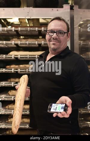 Der französische Bäcker Jean-Louis Hecht steht neben seinem Baguette-Spender, dem PaniVending, während seiner Einweihung vor der Bäckerei "La Panamette" in Paris, Frankreich am 9. Oktober 2014. PaniVending ist der erste Automaten für frisches Brot in der Hauptstadt. Hecht gewann den 1. Preis des Concours Lepine 2014, einem französischen jährlichen Wettbewerb für Erfinder. Foto von Stephane Lemouton/ABACAPRESS.COM Stockfoto